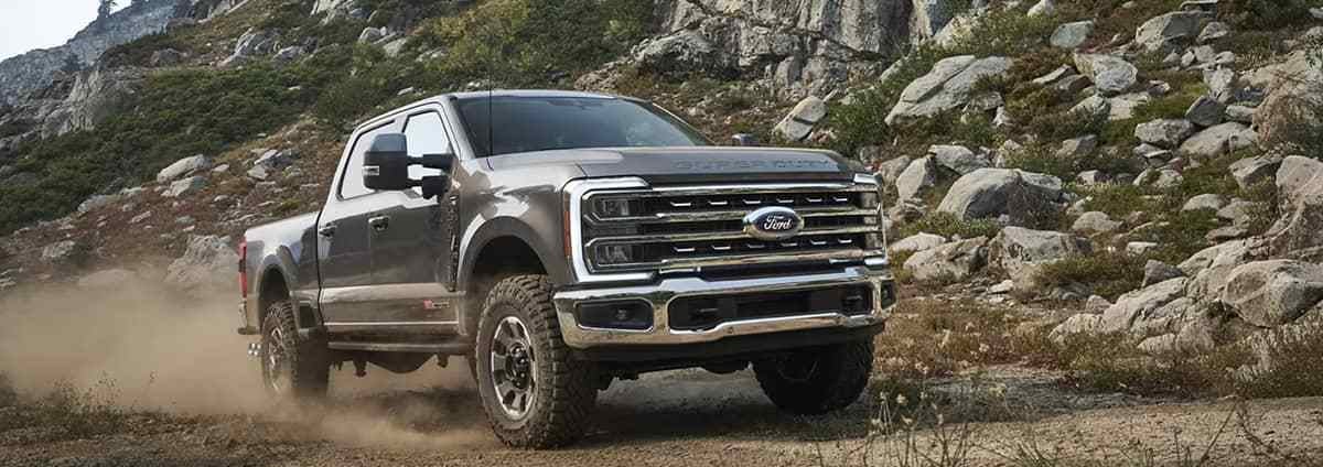 a grey truck driving on gravel road