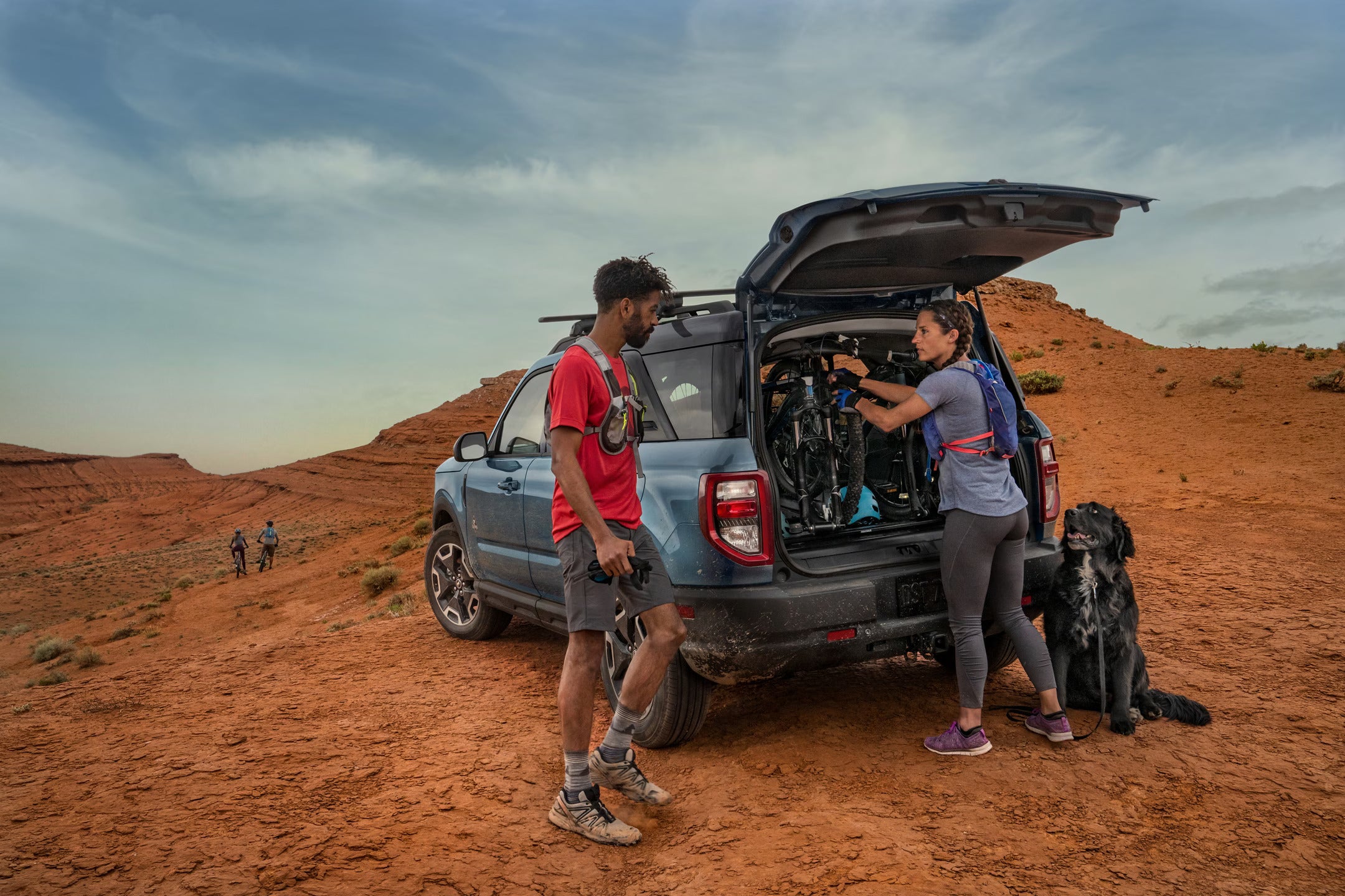 two people unpacking gear out of an suv