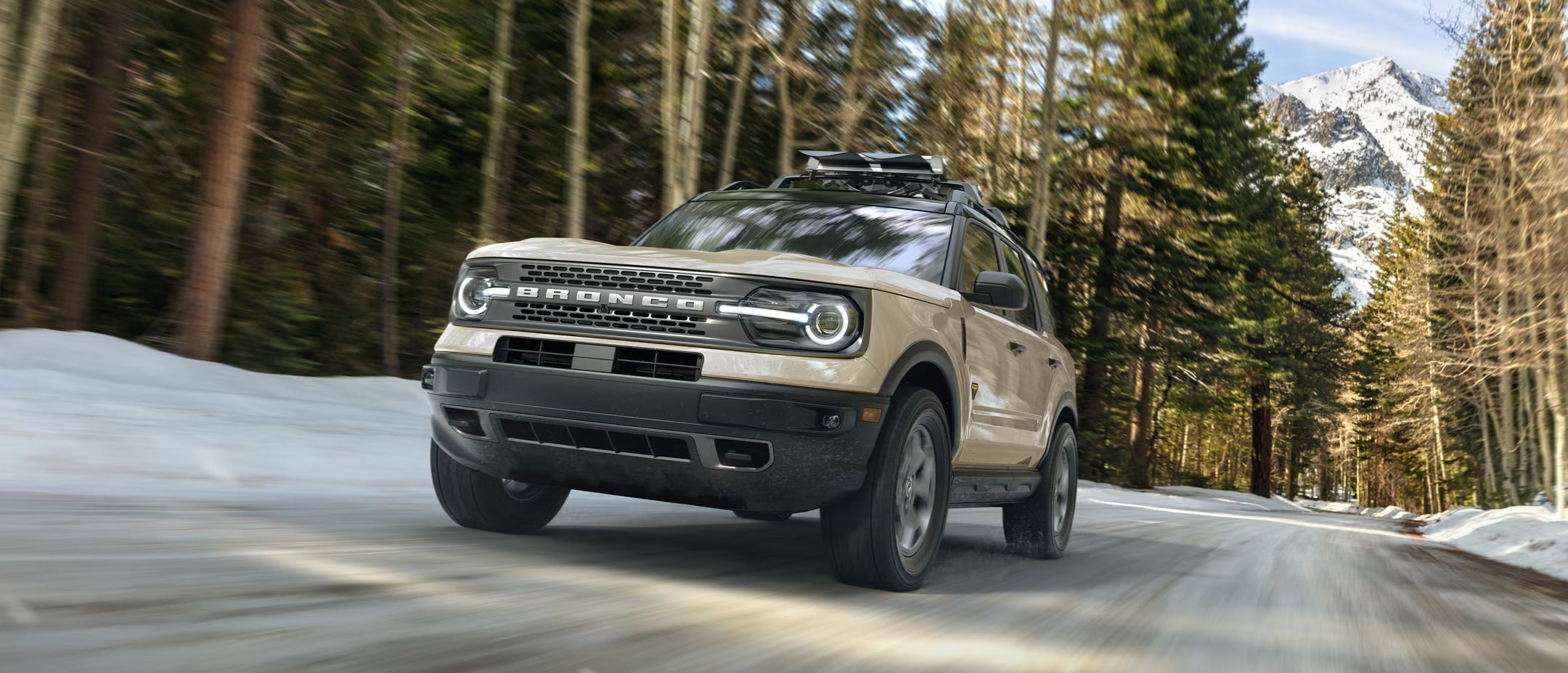 a beige suv driving on a road
