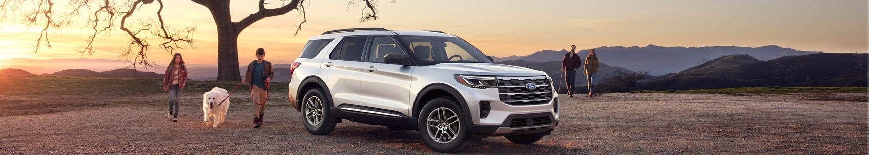 Ford Explorer parked on an open dirt road with family surrounding it