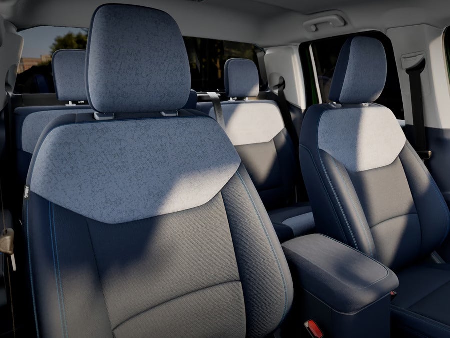 A view of the Ford Maverick’s front and rear seats with a mix of light and dark upholstery, showcasing the comfortable and spacious seating design.
