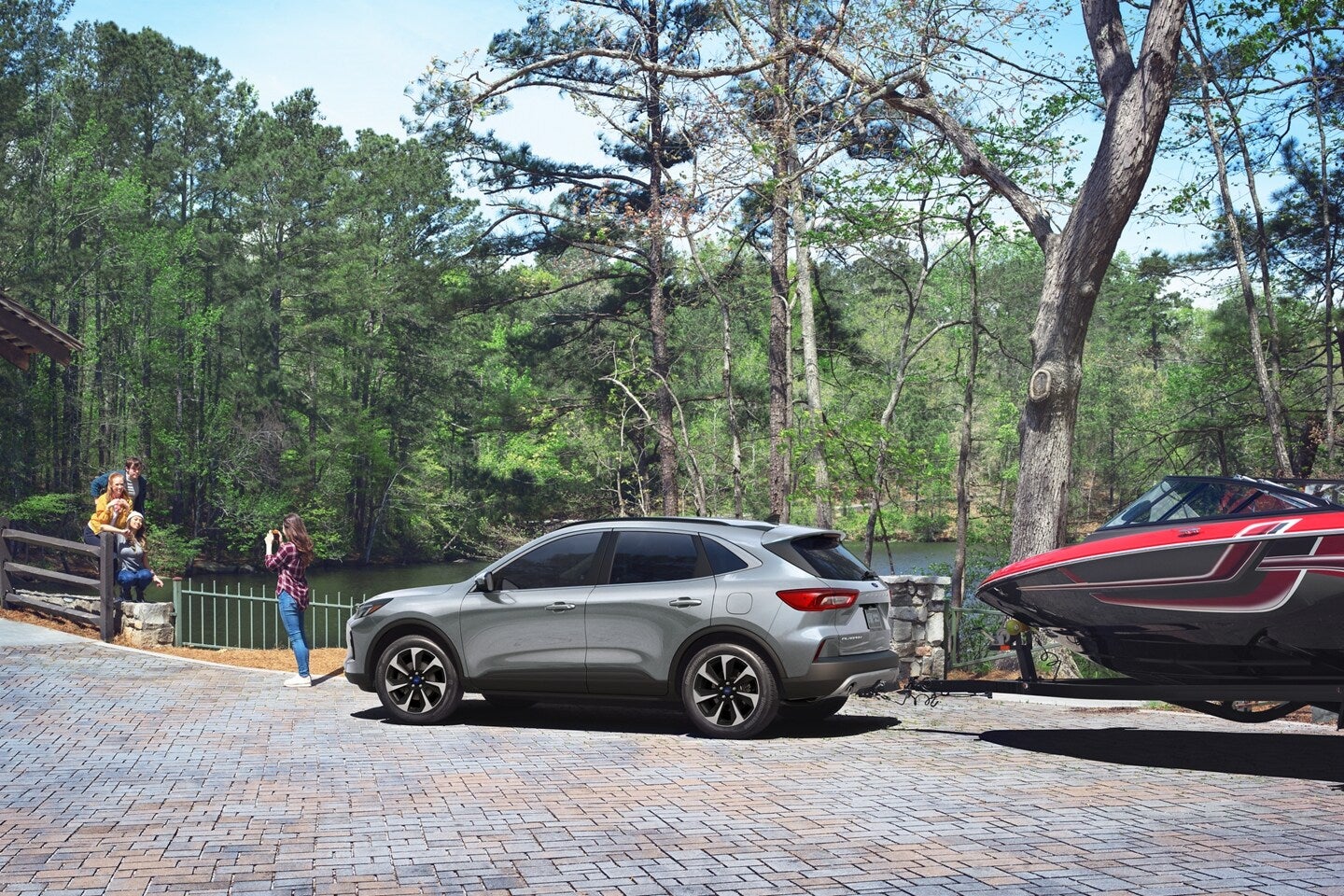 a silver suv hauling a red speed boat