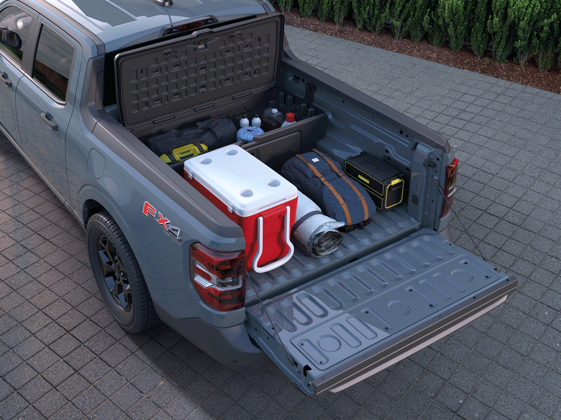 An overhead view of a gray Ford Maverick FX4 parked, with its truck bed organized with camping and travel gear, demonstrating its practical storage capabilities.