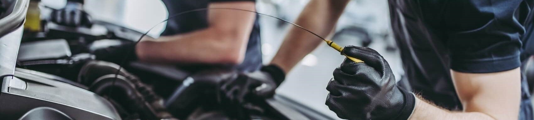 Ford Certified Technician doing routine maintenance work on vehicle at Ford Service Center